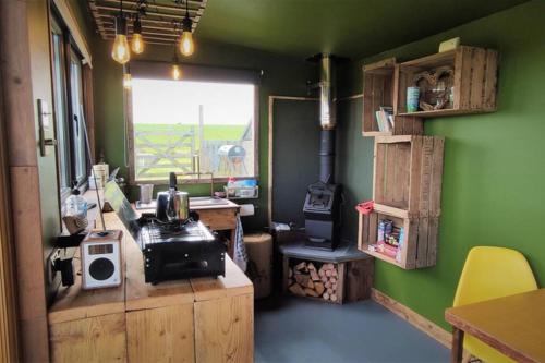 圣梅尔林The Bolt Hole的客房设有带炉灶和绿色墙壁的厨房。