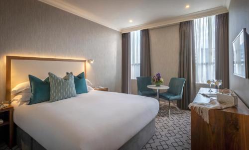 戈尔韦维多利亚酒店的酒店客房设有一张大床和一张桌子。
