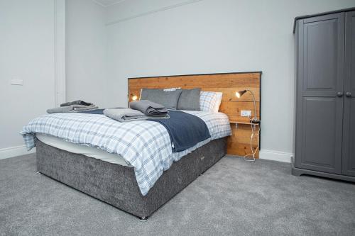 DundrumRooms@Mourne的一间卧室配有一张大床和木制床头板