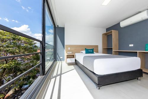 麦德林Ayenda Zona Verde的一间卧室设有一张床和一个大窗户