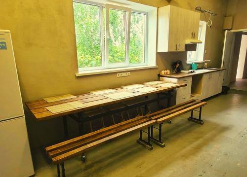 乌曼岛Uman Welcome Hostel的厨房配有木桌和长凳