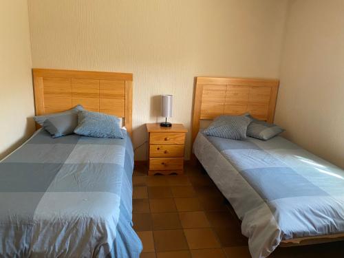 CanenciaSierra Norte的一间卧室配有两张床和床头灯。