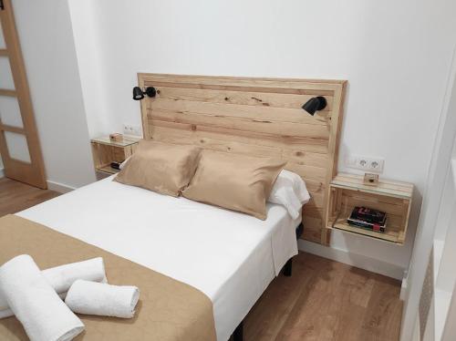 拜纳APARTAMENTO TURISTICO LEO BAENA的一间卧室配有一张大床和木制床头板