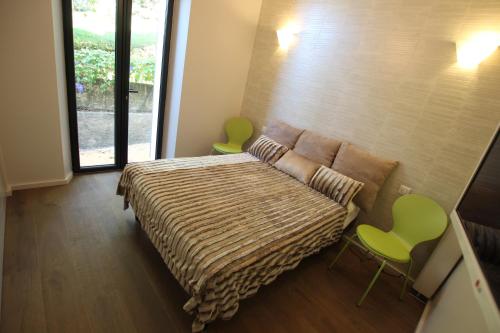 戛纳SUPERBE MAISON DE VILLE的一间卧室配有一张床和两张绿色椅子