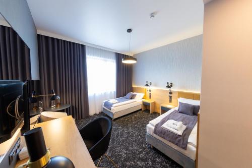 谢德尔采Hotel & SPA Hetman的酒店客房配有两张床和一张书桌