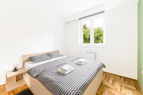 克拉古耶瓦茨Djokic Apartments的白色的卧室设有床和窗户