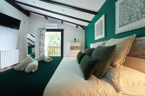宏达瑞比亚Villa Higer的一间卧室设有一张带绿色墙壁的大床