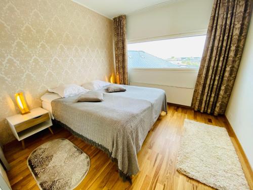 塔林Cozy Lootsi Residence with Sauna and Balcony - Tallinn city centre的一间卧室设有一张床和一个大窗户