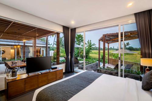 乌布Coconut Grove Villa by BaliSuperHost的一间卧室设有一张大床和一个大窗户