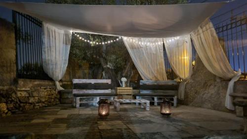 焦维纳佐B&B villa Maria的一间设有两张长椅和窗帘及灯的房间
