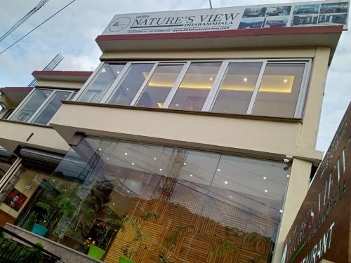 达兰萨拉Hotel Nature's View的大楼前方装有玻璃窗的商店