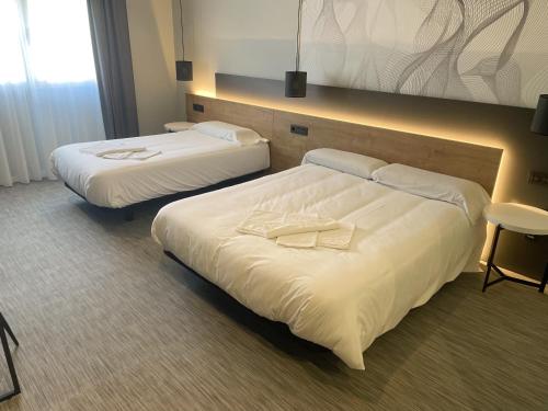 欧特瑞奥德瑞Area 507的配有白色床单的酒店客房内的两张床
