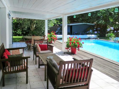 安德诺莱斯贝恩Holiday Home Villa Katy - ADS165 by Interhome的游泳池旁带桌椅的天井