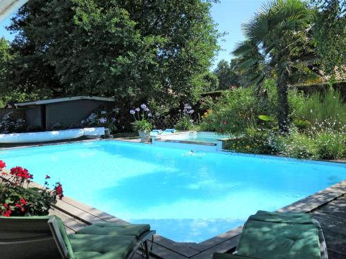 安德诺莱斯贝恩Holiday Home Villa Katy - ADS165 by Interhome的一个带椅子和鲜花的大型蓝色游泳池