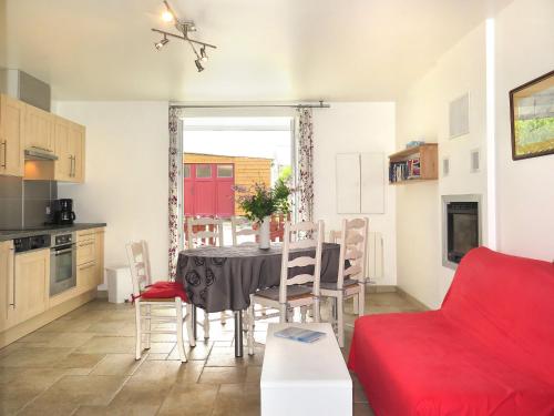 康卡勒Holiday Home La Pailloussette - A的厨房以及带桌子和红色沙发的用餐室。