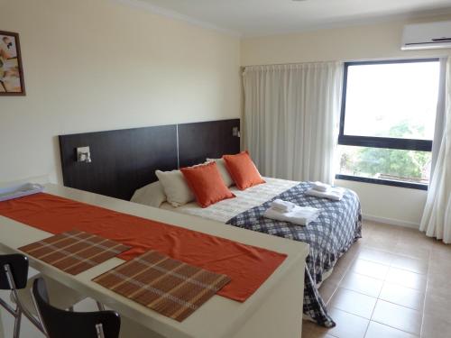维多利亚Rio Manso Apart Hotel的一间卧室设有一张床和一个大窗户