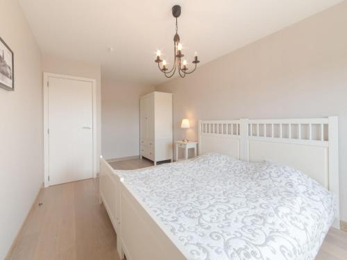 布列登Apartment Residentie Albatros by Interhome的白色卧室配有一张大床和吊灯