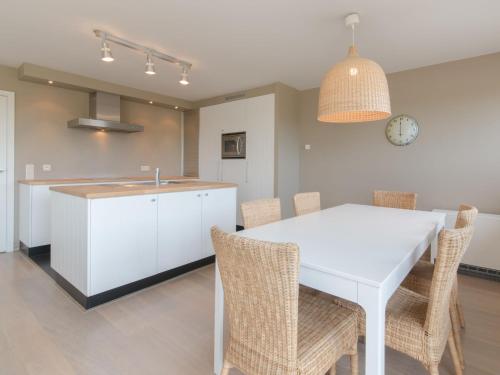 布列登Apartment Residentie Albatros by Interhome的厨房以及带白色桌椅的用餐室。