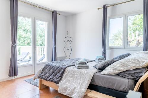 弗雷瑞斯Le Grand Thao的一间卧室配有一张带灰色床单和窗户的床。