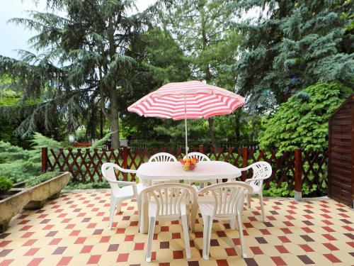 巴拉顿菲兹弗Holiday Home Pinus 2 by Interhome的一张桌子,上面摆放着红色和白色的遮阳伞和椅子