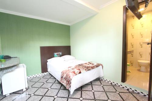马瑙斯拉戈阿酒店的一间卧室配有一张床,浴室设有卫生间