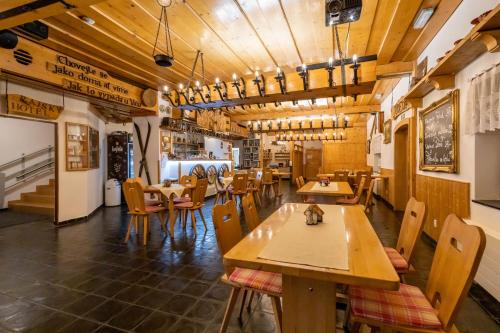 Malenovice拉斯卡布达霍思基酒店的一间设有木桌和椅子的餐厅