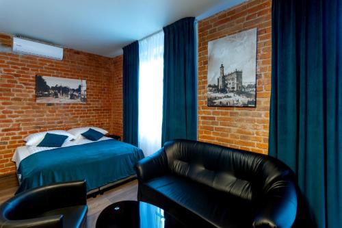 桑多梅日Apart Podolski的一间卧室配有一张床、一张沙发和一把椅子