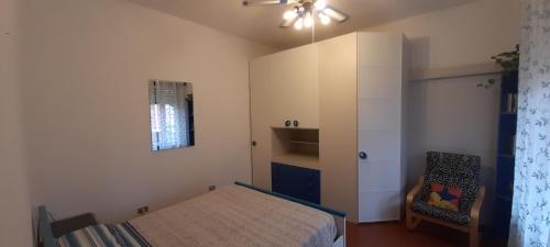 米兰DA PINA的一间小卧室,配有一张床和一把椅子