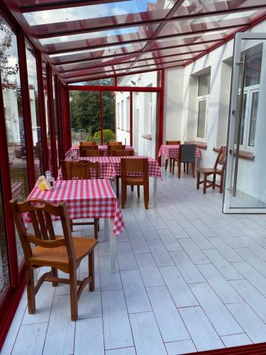 科鲁兹尼亚尼Gościnec pod lipami的庭院配有桌椅和红色及白色的桌布