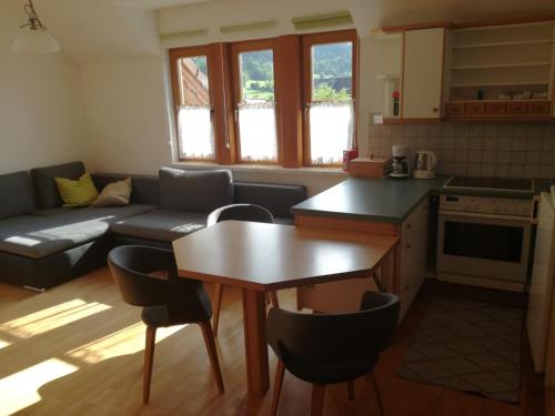 ObersdorfGästehaus Lemmerer的厨房以及带桌子和沙发的客厅。
