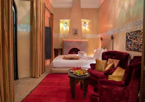 马拉喀什罗曼斯庭院旅馆的一间卧室配有一张床、一张沙发和一张桌子