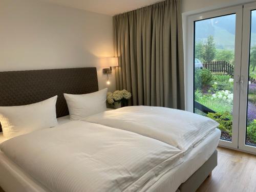 奥泊维森塔尔Simon´s Ferienwohnungen的卧室设有一张白色大床和一扇窗户。