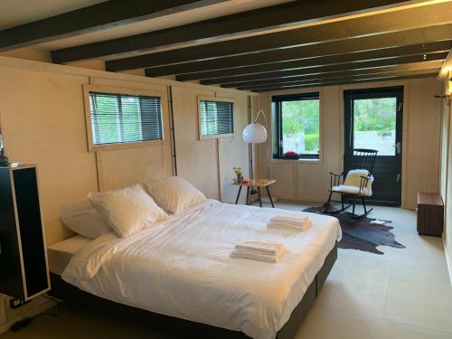 MarrumHet Lage Noorden的一间卧室配有一张带白色床单的大床