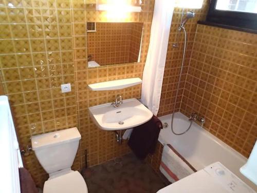 莱热Les Gets apartment的浴室配有卫生间、盥洗盆和浴缸。