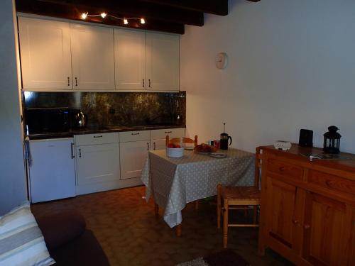 莱热Les Gets apartment的厨房配有桌子和白色橱柜。