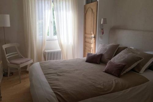 埃圭斯海姆La Maison du Rempart的一间卧室配有一张大床、椅子和窗户