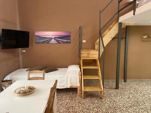 阿沃拉I VACANZIERI的一间卧室配有带梯子的双层床和一张带桌子的床。