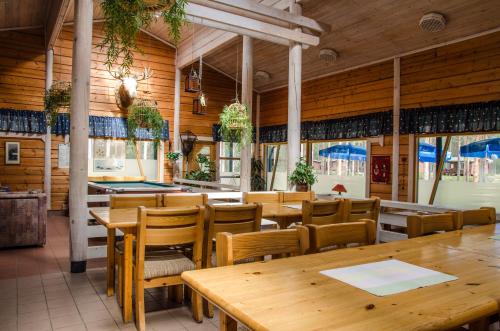 萨里耶尔维Ahvenlampi Camping的餐厅拥有木墙和桌椅