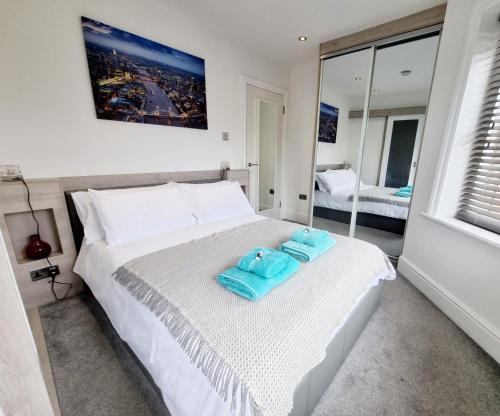 伯恩茅斯Bournemouth Luxury Apartment的一间卧室配有一张床,上面有两条毛巾