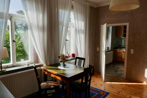 FrankenbergFerienwohnung ANDERE ZEITEN的一间带桌椅和窗户的用餐室