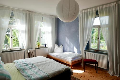 FrankenbergFerienwohnung ANDERE ZEITEN的一间卧室设有两张床和两个窗户。