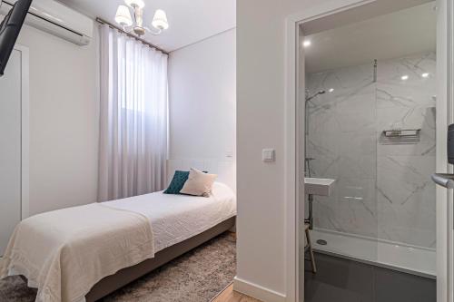 埃武拉Templo Boutique Hotel的一间卧室设有一张床和一个玻璃淋浴间