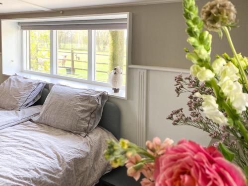 Losser4seasonshouse的一间卧室设有床、窗户和鲜花