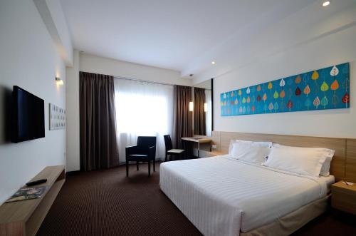 阿罗士打星城大酒店的一间酒店客房,配有一张白色的床和一张书桌
