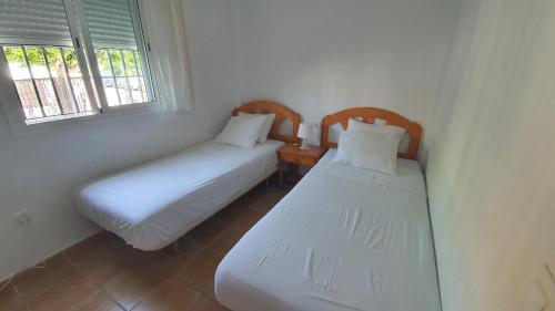 罗塔Apartment in Rota Cadiz, Air Cond, Wifi, Patio的带2扇窗户的小客房内的2张床