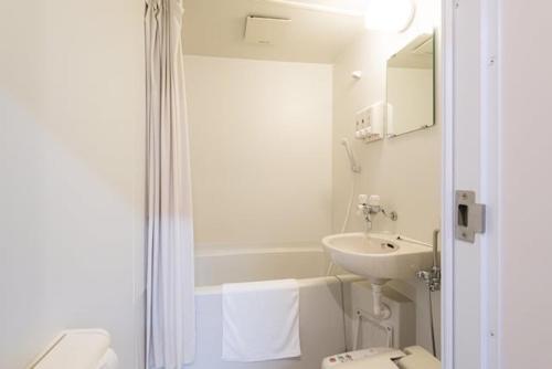 TaruiHotel Sunmarine的白色的浴室设有水槽和卫生间。
