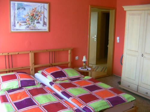 奥斯特西巴德钦诺维茨Ferienhaus Lukas的一间卧室设有两张床和红色的墙壁