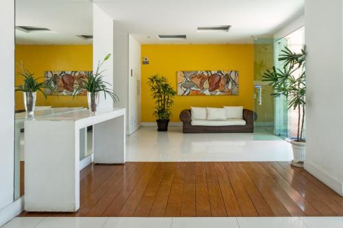 里约热内卢Bora Bora Resort Barra da Tijuca的客厅设有黄色的墙壁和沙发