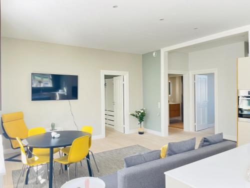 奥尔堡aday - 2 bedroom with modern kitchen and free parking的客厅配有沙发、桌子和黄色椅子