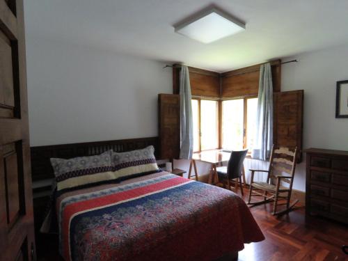 LebenaEl Chalet de la Poza - Río, barbacoa, Wifi, zona de trabajo, vistas.的卧室配有一张床和一张桌子及椅子